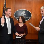 Left to right: Dr. Sharpless (joined by his wife, Julie Lund Sharpless, MD), is sworn in as NCI director by Acting Secretary of Health and Human Servicesâ€™ Eric D. Hargan.